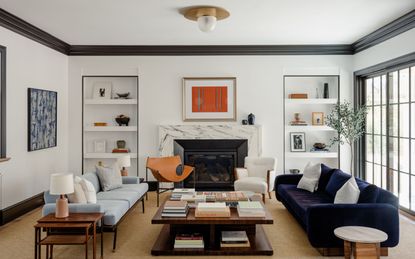 living room with light gray walls and black trims, matble fireplace, dark blue and light blue sofa, wooden coffee table