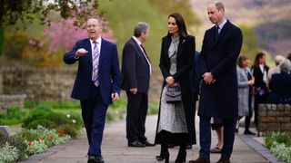 David Davies walks with Prince William, Prince of Wales and Catherine, Princess of Wales during a visit to the Aberfan Memorial Garden