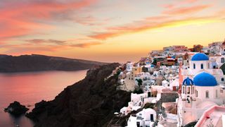 View over Santorini at sunset with the caldera in the background.