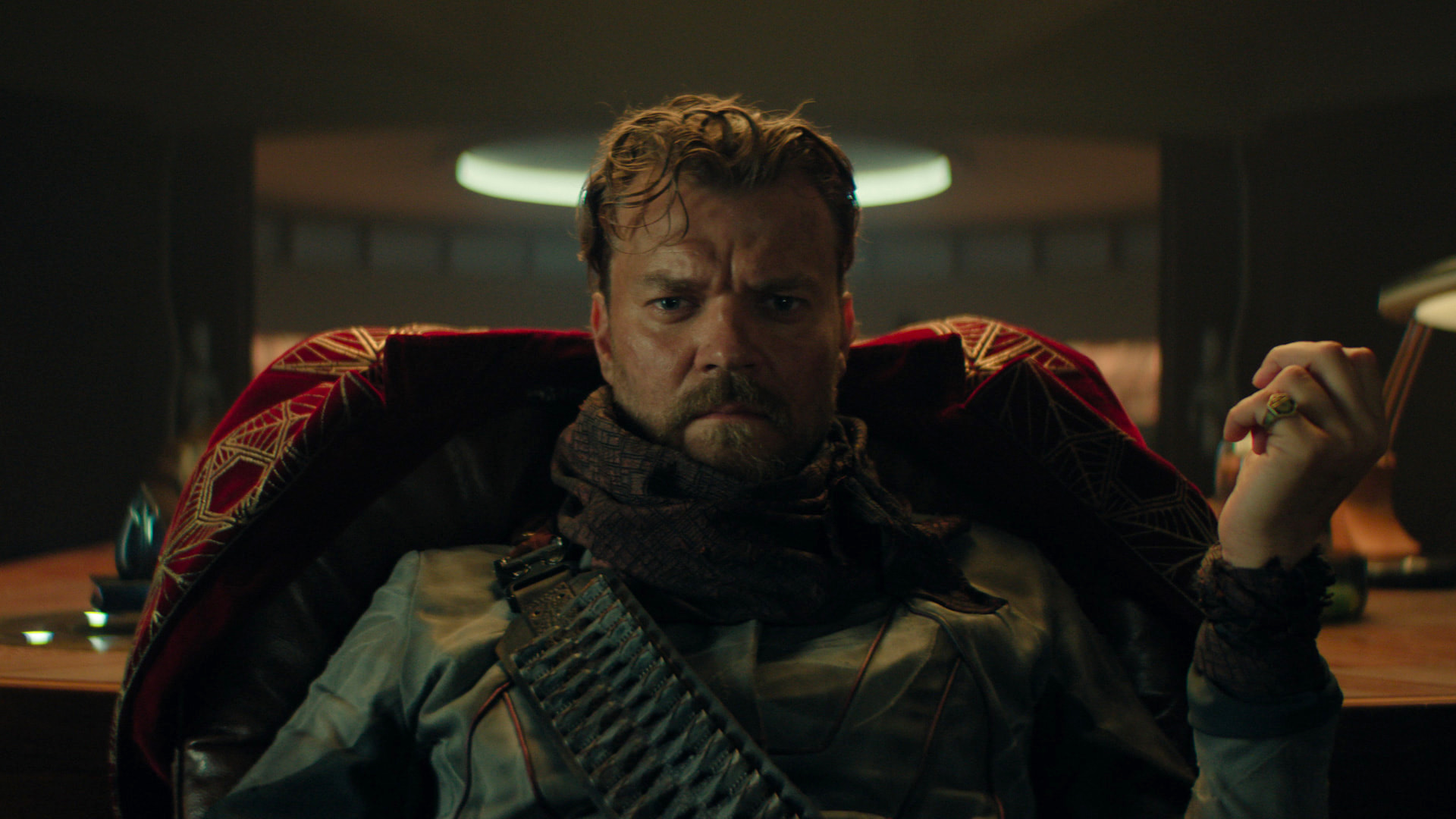 a man sits in a chair with a pensive gaze