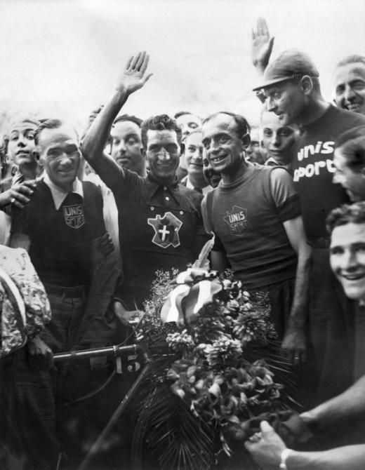 Italian Gino Bartali, surrounded by fans, waves to the crowd, 31 July 1938 at the Parc des princes in Paris, after winning his first Tour de France.