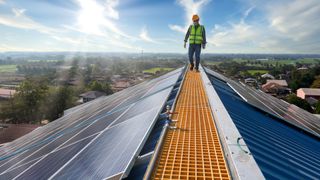 A photo of a technician on a roof checking solar panels. Renewable-energy storage involves storing energy from renewable sources such as solar.