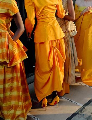 Details of outfits in shades of yellow worn by models and captured backstage at Christopher John Rogers Resort 2023