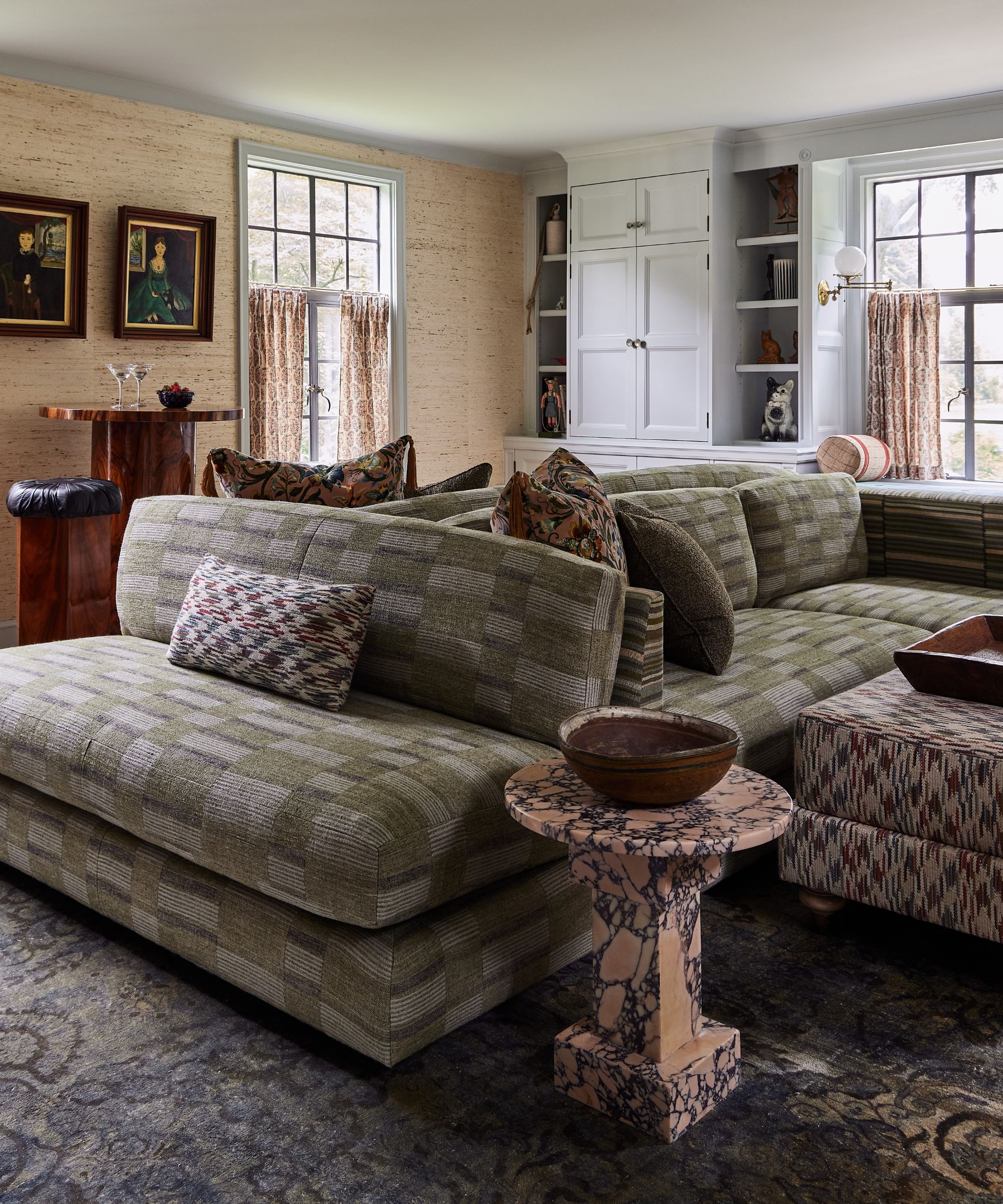 an open living room with grasscloth walls, painted blue gray trims and ceiling, marble fireplace, and a plaid three sided sofa
