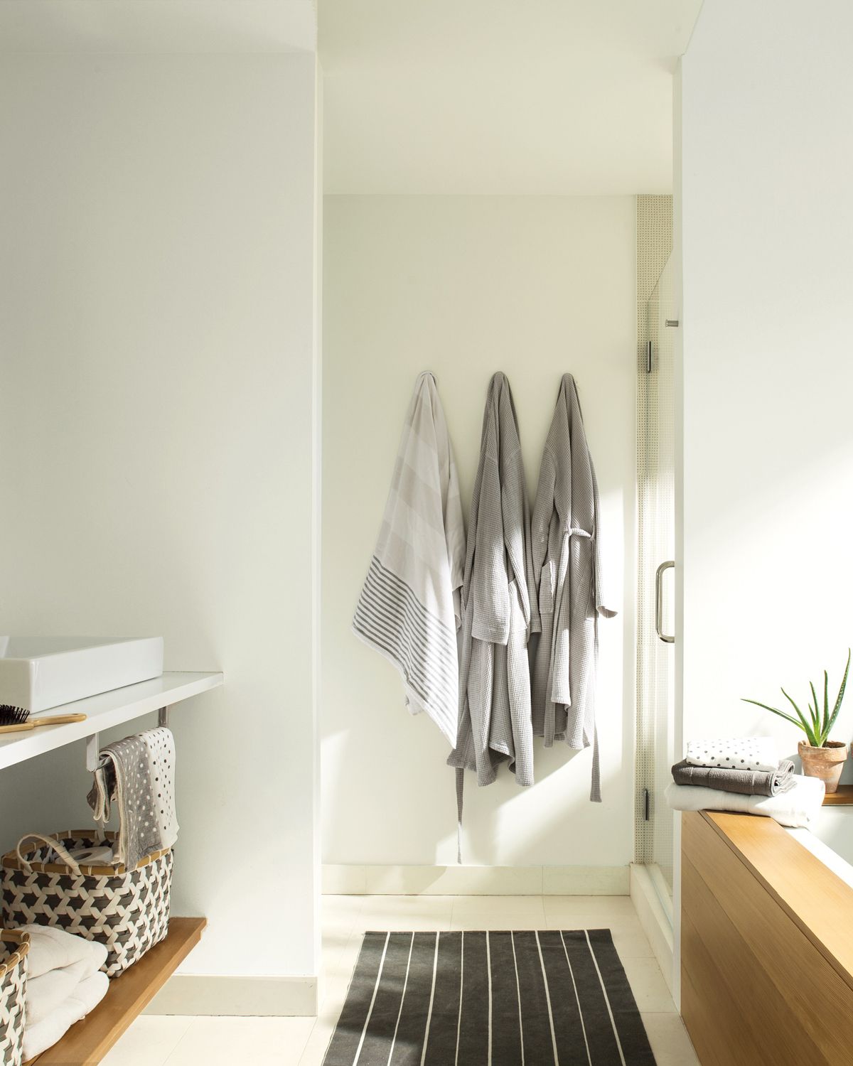White bathroom with shower area and sink all paint in Chantilly Lace white. paint color by Benjamin Moore