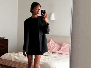 Woman taking a mirror selfie wearing a black outfit