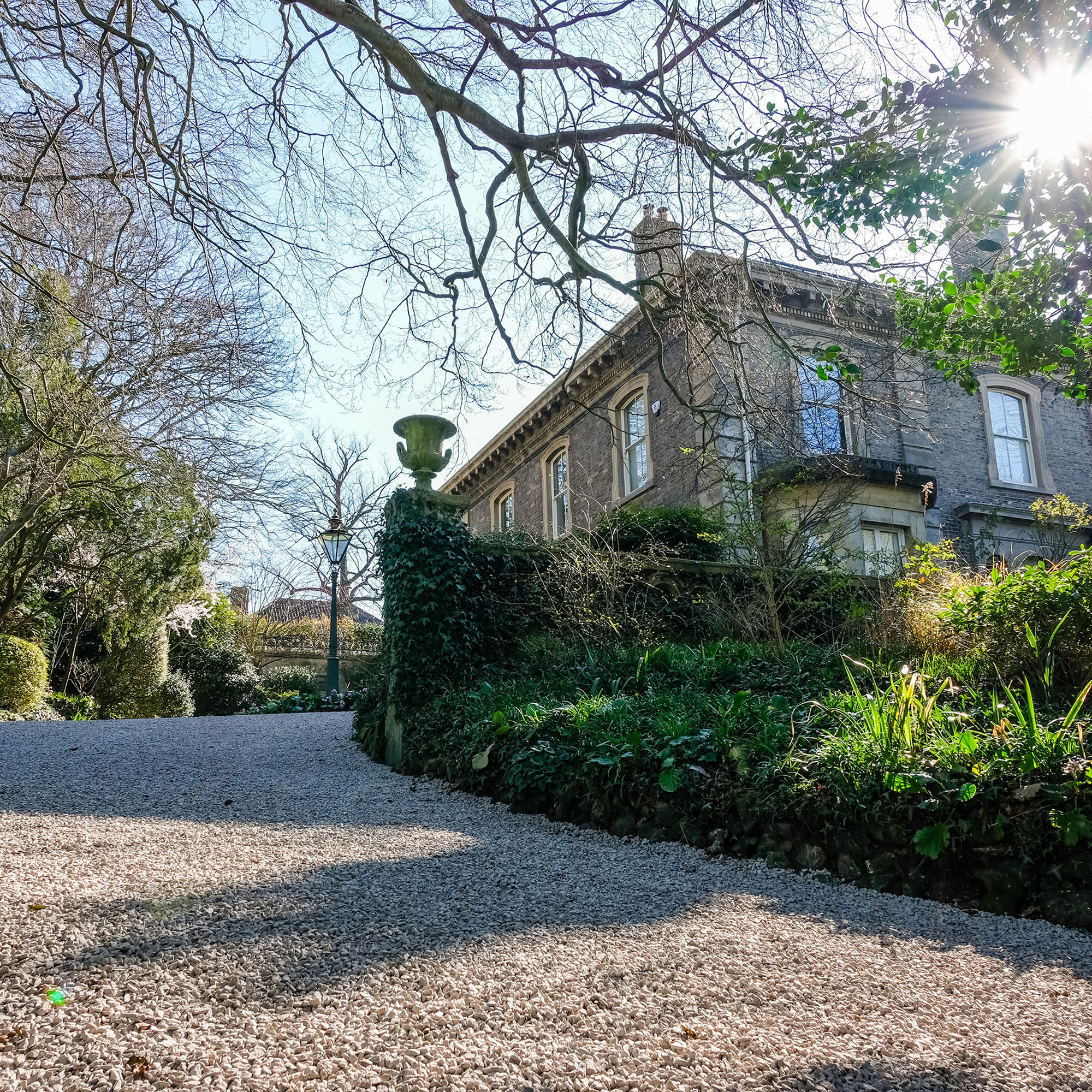 sloping gravel driveway to grand old house