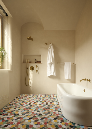 plastered wet room with bathtub and patterned multicolor tiles