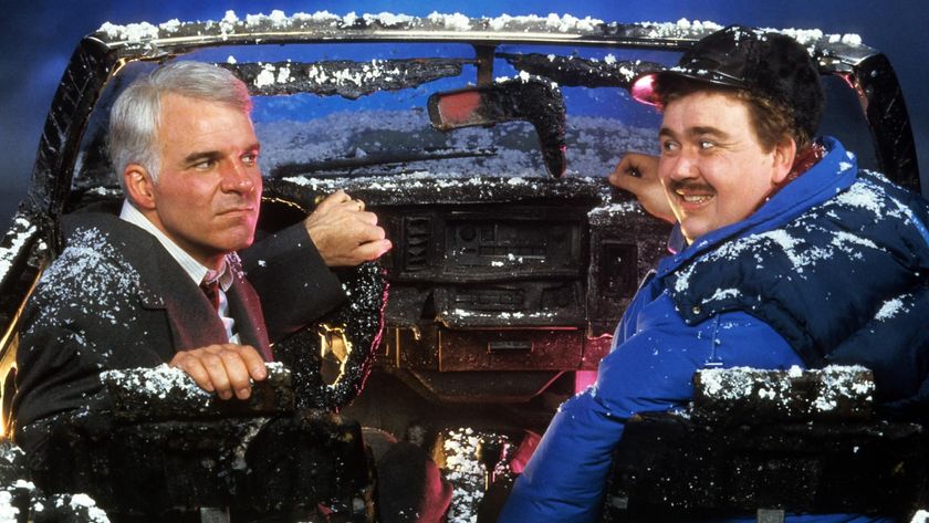 Steve Martin and John Candy sit in a snowy car in Planes, Trains and Automobiles