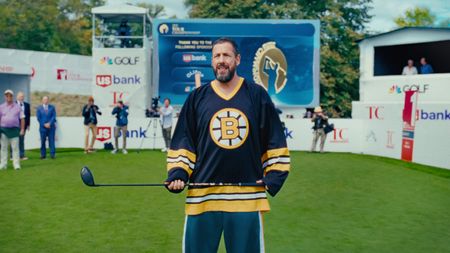 Adam Sandler as Happy Gilmore, standing with a golf club in hand, in Happy Gilmore 2.