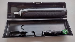 Image shows a black Oral B Genius X toothbrush inside its travel case.