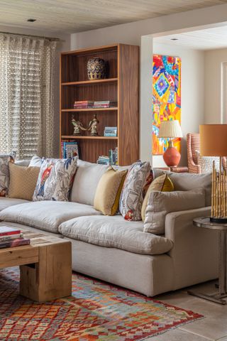 Grey sofa, yellow lamps, cushions and artwork
