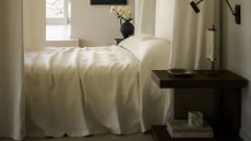 a white bedroom with soft drapery and a four poster bed