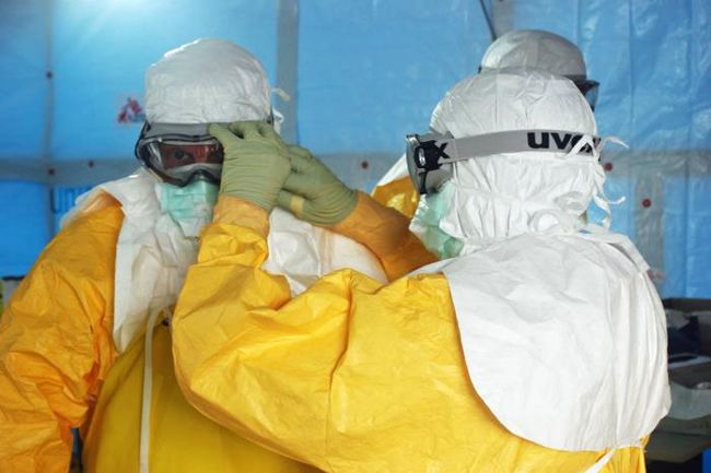 2014 Ebola salgını sırasında Liberya'da bir Ebola tedavi ünitesine girmeden önce sağlık çalışanları koruyucu ekipman giydiler ..