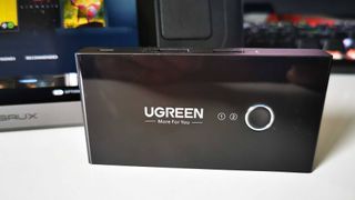 Ugreen USB swithc on white desk with Steam Deck screen in backdrop