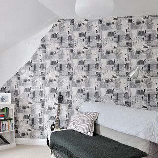 guest bedroom with pictorial wallpaper and sofa with cushion