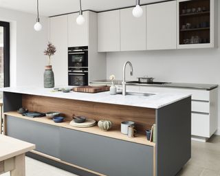 Modern white kitchen ideas with a white-topped grey and wood island and handlessless white gloss cabinetry