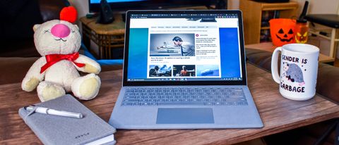 El Microsoft Surface Laptop 4 sobre una mesa con un café y un cuaderno al lado