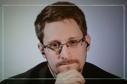 Edward Snowden looking into the camera with his hand on his chin