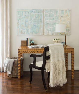 neutral bright study desk with two matching wall art canvases and throw blankets