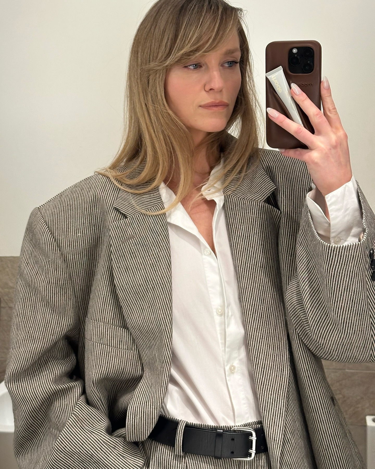 A photo of @jeanettemadsen_ taking a selfie in the mirror wearing a grey blazer