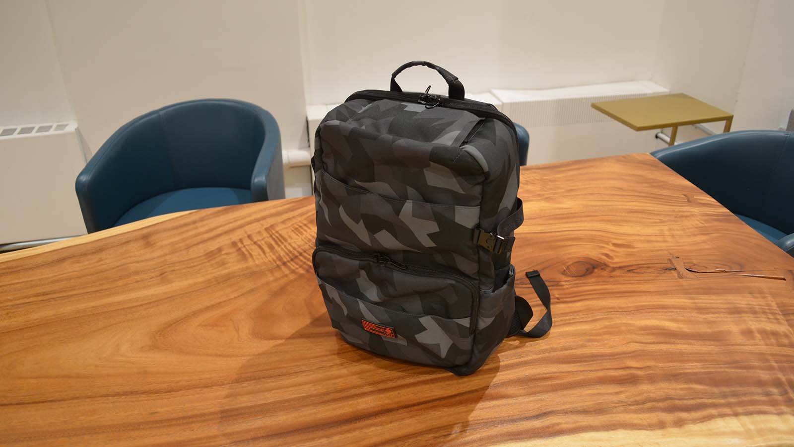 A Hex Technical backpack on a polished woodgrain table