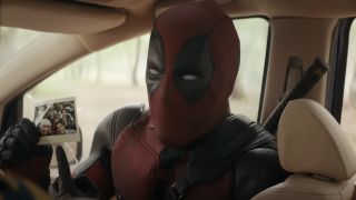 Close-up of Deadpool pointing to Polaroid picture of all of his friends in Deadpool & Wolverine