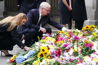 Prince Andrew and his daughter Princess Beatrice look at flowers left for the late Queen Elizabeth outside Balmoral in Scotland