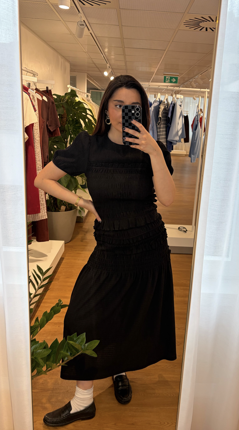 Marina is wearing a black top and skirt