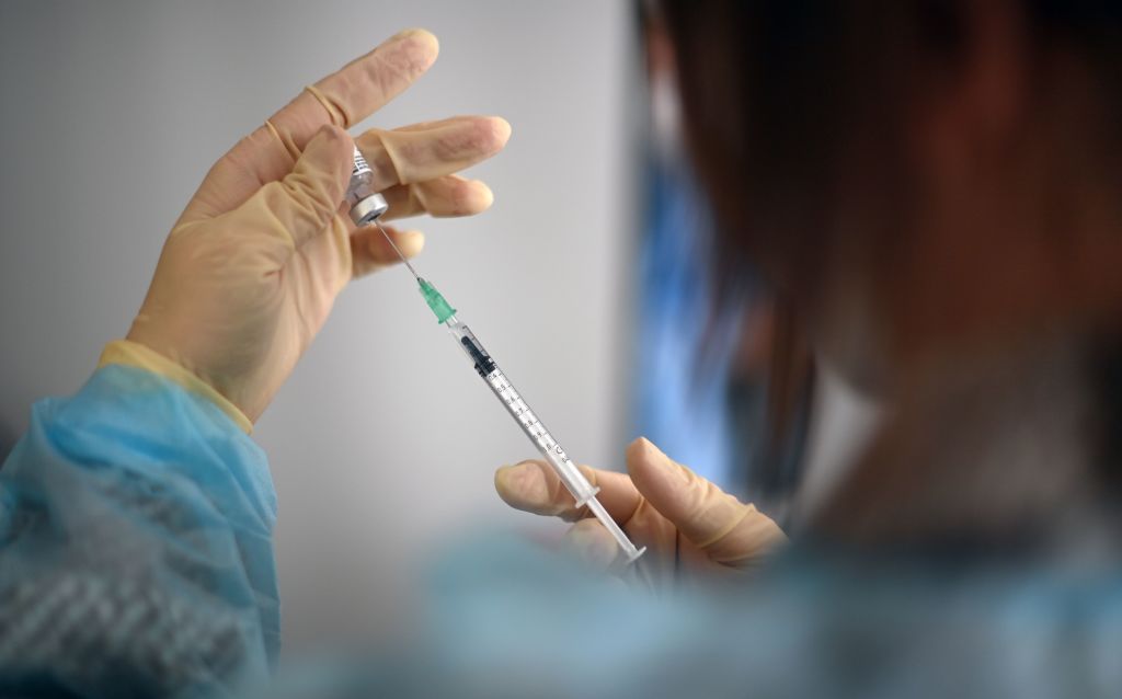 Health care worker preparing COVID-19 vaccine.