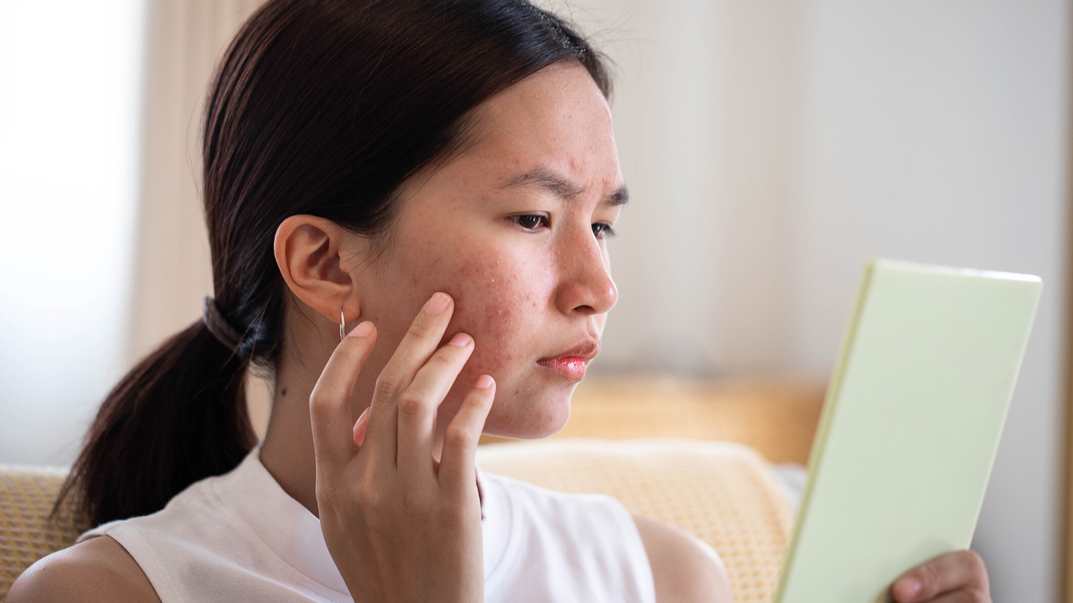 Woman looking at her face in the mirror