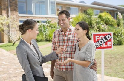 Realtor giving couple keys to new house