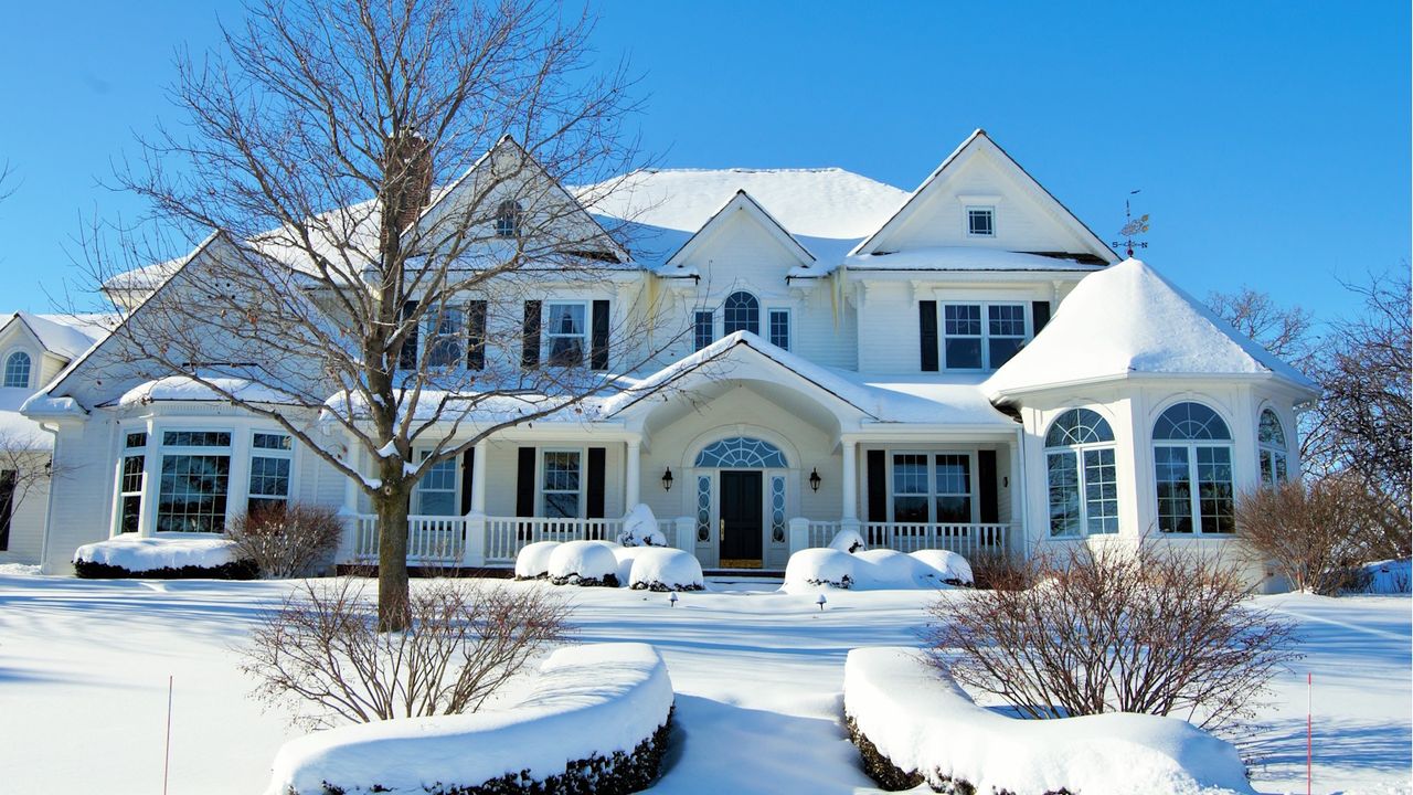 Snowy house on a sunny day, bright blue sky behind