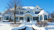 Snowy house on a sunny day, bright blue sky behind