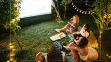 Friends watching a film on a projector outside in the garden