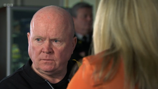 Phil Mitchell looks concerned as Sam Mitchell talks to him