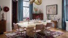 A dining room with a rectangular table and a statement brass pendant light