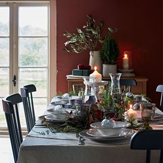 dinning room with red wall white door dinning table chair and candle