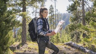 Woman checking map wearing flannel shirt