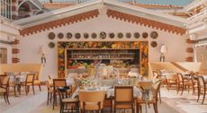 A white-washed coastal hotel boasts Mediterranean decor with minimal lines, occasional splashes of color, plenty of natural linens, plants, and wood accents, and sunshine throughout.