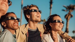 People watching a solar eclipse wearing glasses