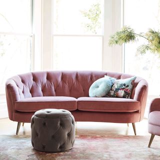 living room with pink sofa and white window