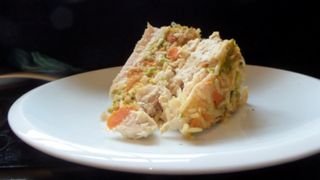 Slice of posh chicken dinner layer cake for dogs on a plate