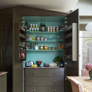 Khaki green pantry unit with cupboard hat