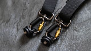 A close-up of the camera mounting system and metal carabiners on the BlackRapid Blackline II Double Camera Harness