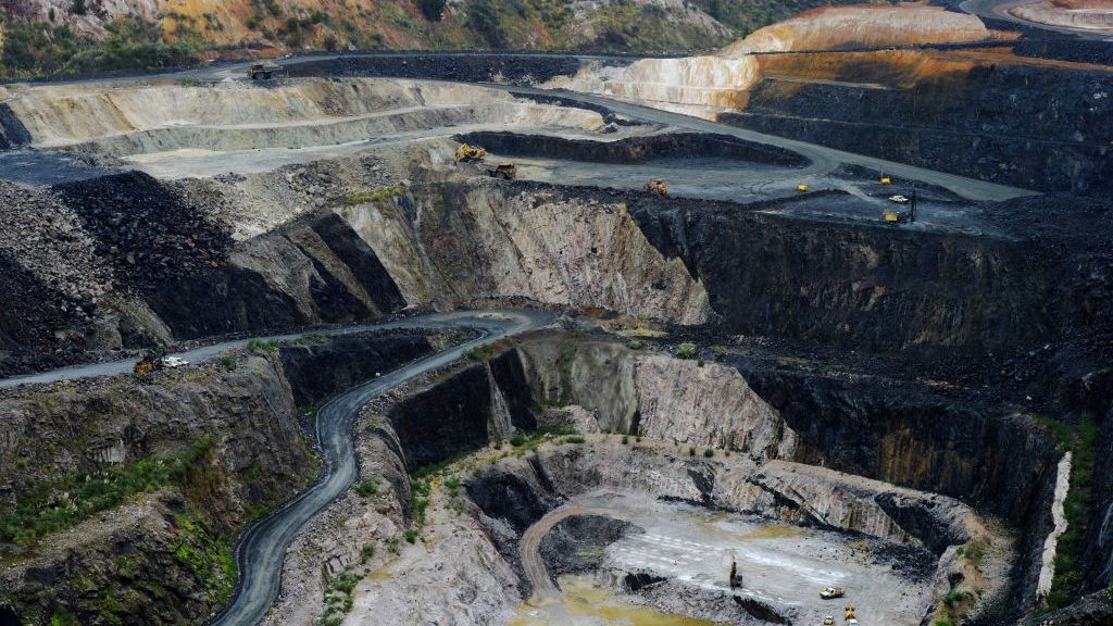 An aerial view of the Albermarle Lithium Mine showing diggers driving on narrow roads around the edge of a large crater