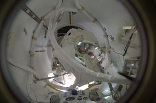 After a long spacewalk, NASA astronaut Peggy Whitson is seen entering the International Space Station's Quest airlock in this photo by ESA astronaut Thomas Pesquet inside the station on Jan. 6, 2017.