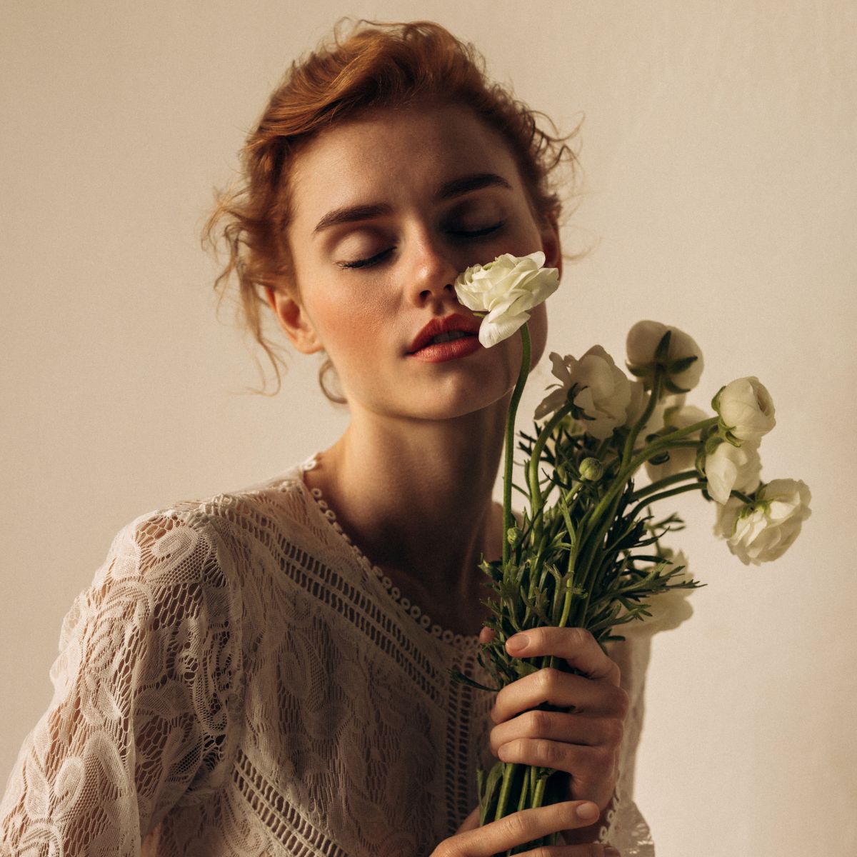 a model in a wedding dress holding a bouquet of ranunculus - wedding beauty timeline