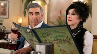 Eugene Levy as Johnny Rose looks as Catherine O'Hara as Moira Rose reads a menu on Schitt's Creek