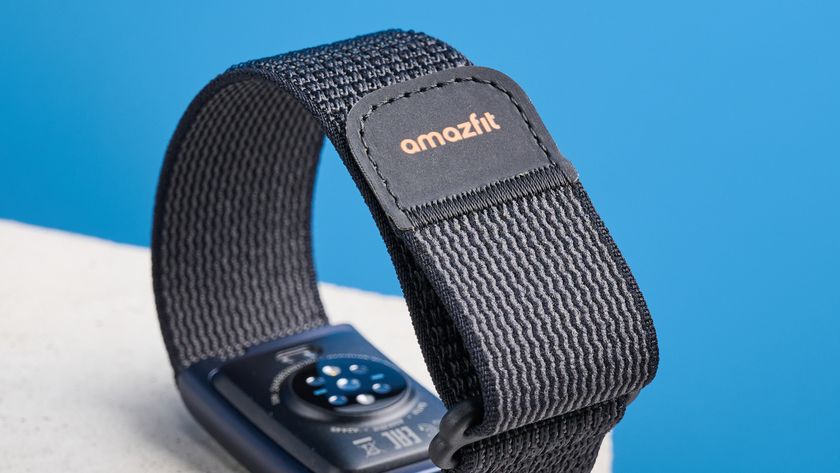 the amazfit helio strap fitness tracker with a screenless design, showing the gray strap worn around the wrist and the charger